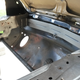 Inside of the new front engine bay of the car, looking at the front crash bar under the hood.